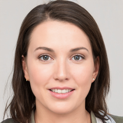 Joyful white young-adult female with medium  brown hair and grey eyes