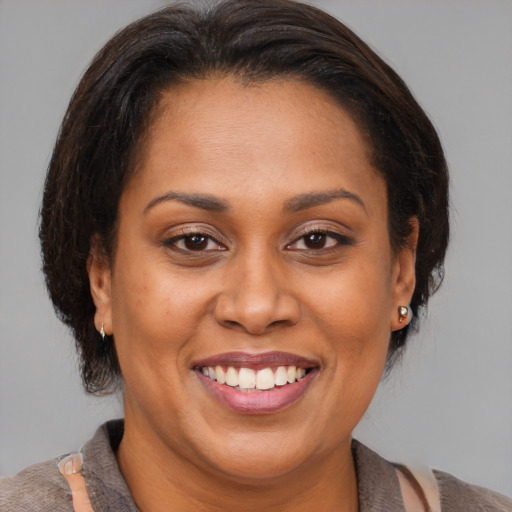 Joyful latino adult female with medium  brown hair and brown eyes