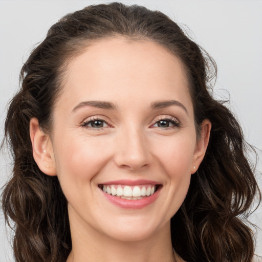 Joyful white young-adult female with long  brown hair and brown eyes