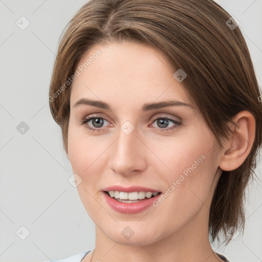 Joyful white young-adult female with medium  brown hair and grey eyes