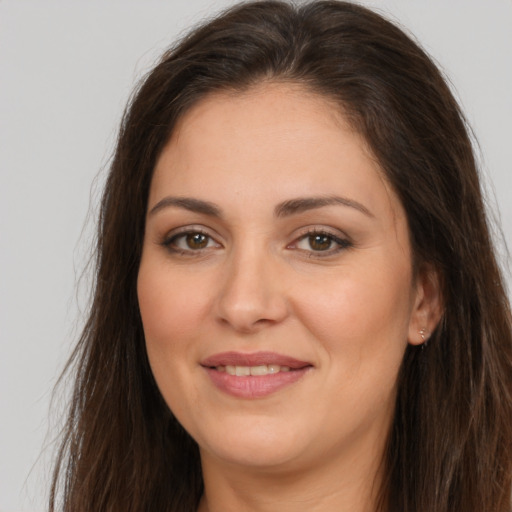 Joyful white young-adult female with long  brown hair and brown eyes