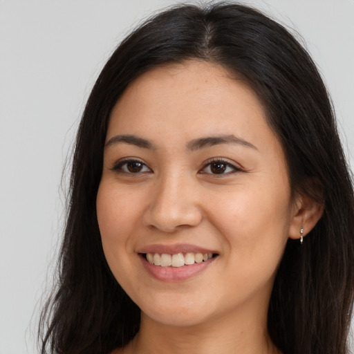 Joyful latino young-adult female with long  brown hair and brown eyes