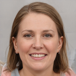 Joyful white adult female with medium  brown hair and grey eyes