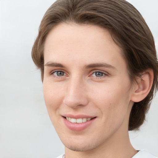 Joyful white young-adult female with short  brown hair and grey eyes