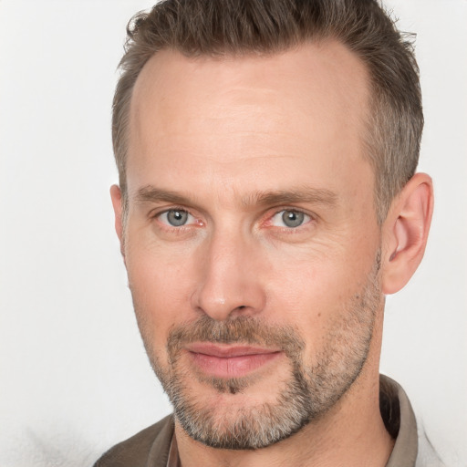 Joyful white adult male with short  brown hair and brown eyes