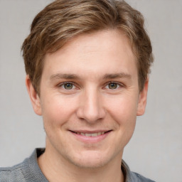 Joyful white young-adult male with short  brown hair and grey eyes