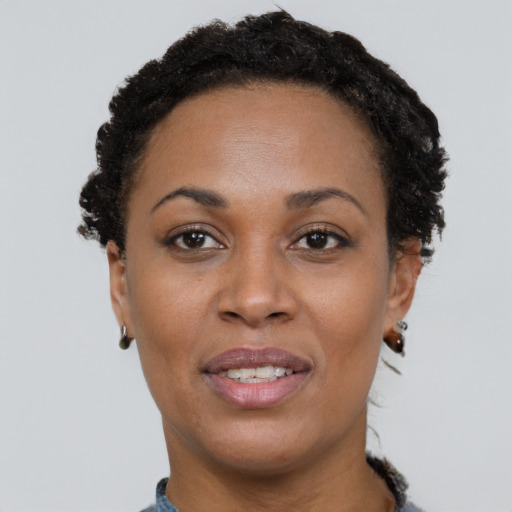 Joyful black young-adult female with short  black hair and brown eyes