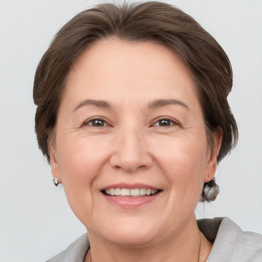 Joyful white adult female with medium  brown hair and grey eyes