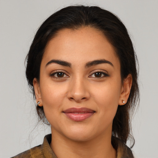 Joyful latino young-adult female with medium  brown hair and brown eyes