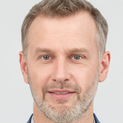 Joyful white adult male with short  brown hair and grey eyes