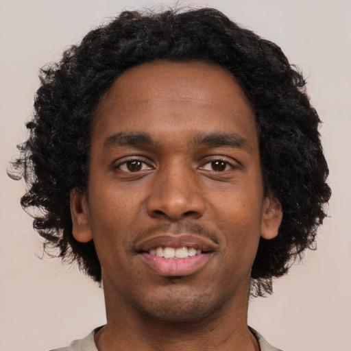 Joyful black young-adult male with short  black hair and brown eyes