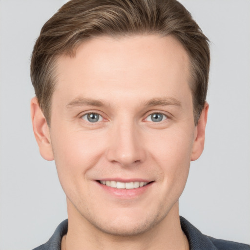 Joyful white young-adult male with short  brown hair and grey eyes