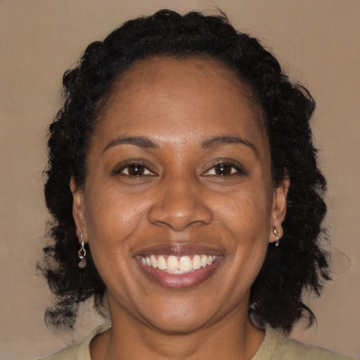 Joyful black adult female with medium  brown hair and brown eyes