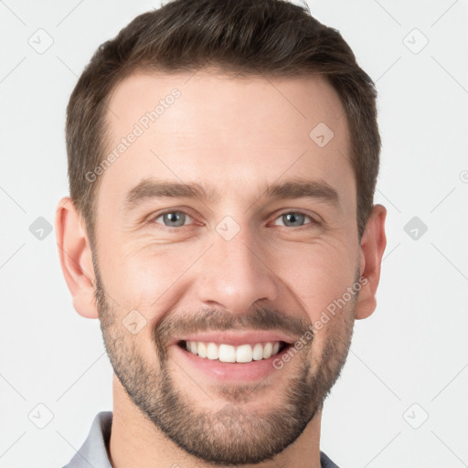 Joyful white young-adult male with short  brown hair and grey eyes