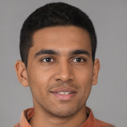 Joyful latino young-adult male with short  brown hair and brown eyes