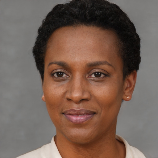 Joyful black adult female with short  brown hair and brown eyes