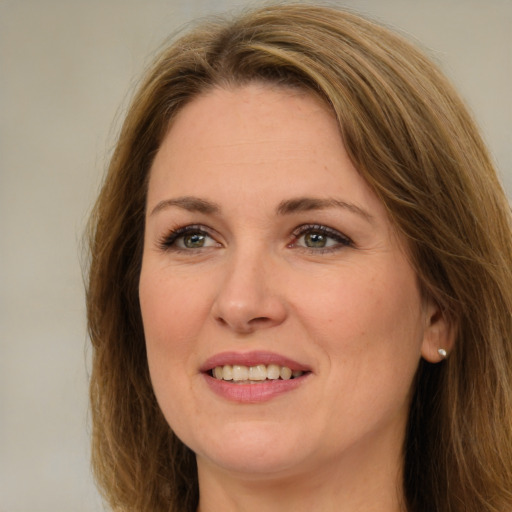 Joyful white adult female with long  brown hair and green eyes