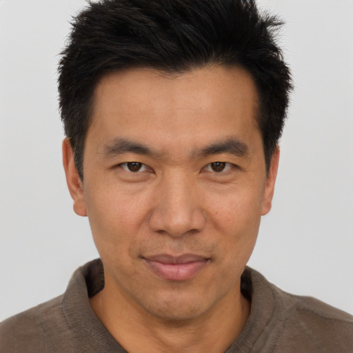 Joyful asian adult male with short  brown hair and brown eyes