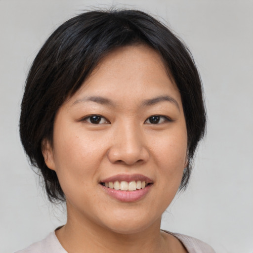 Joyful asian young-adult female with medium  brown hair and brown eyes