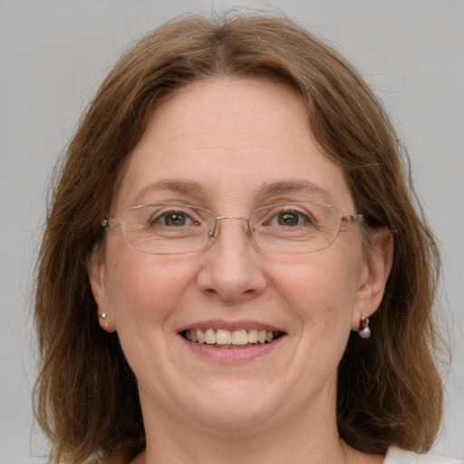 Joyful white adult female with medium  brown hair and green eyes