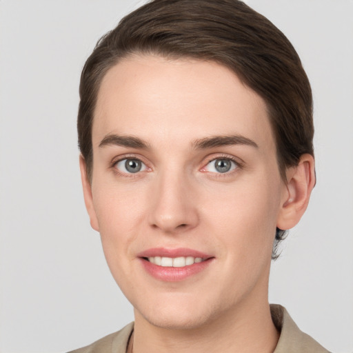 Joyful white young-adult female with short  brown hair and grey eyes