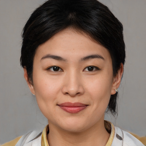 Joyful asian young-adult female with medium  brown hair and brown eyes