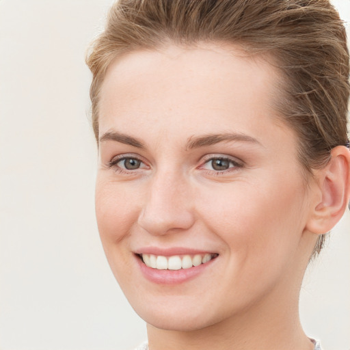 Joyful white young-adult female with short  brown hair and grey eyes