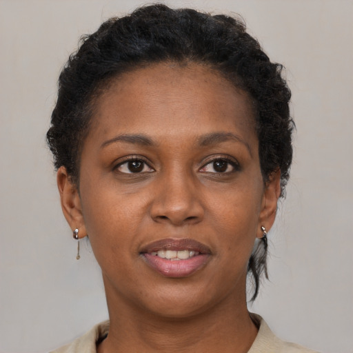 Joyful black young-adult female with short  brown hair and brown eyes