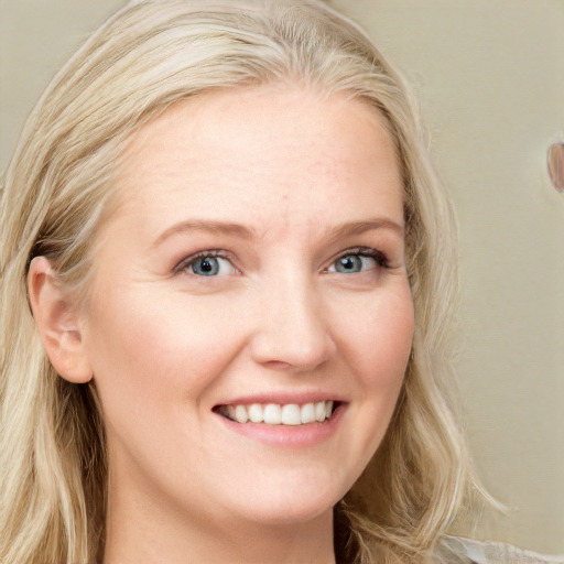 Joyful white young-adult female with long  blond hair and blue eyes