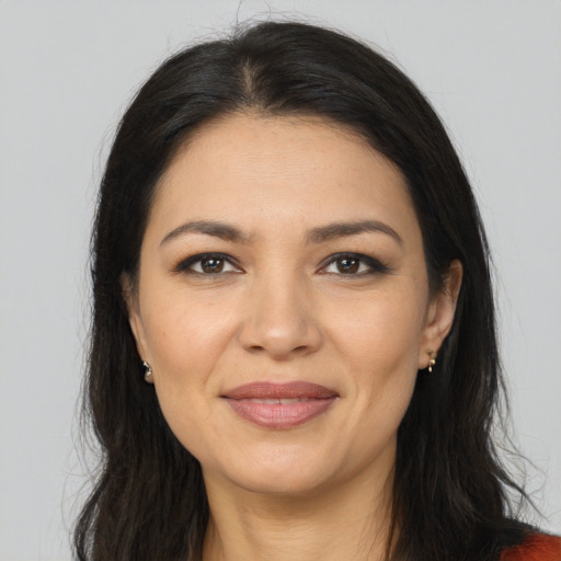 Joyful latino young-adult female with long  brown hair and brown eyes