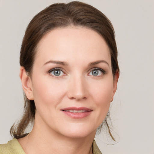 Joyful white young-adult female with medium  brown hair and grey eyes