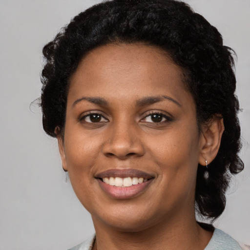 Joyful black young-adult female with short  black hair and brown eyes