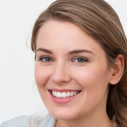 Joyful white young-adult female with long  brown hair and blue eyes