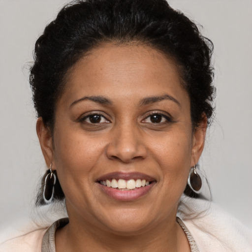 Joyful latino adult female with medium  brown hair and brown eyes