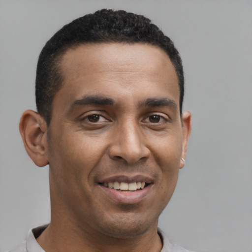 Joyful latino young-adult male with short  brown hair and brown eyes