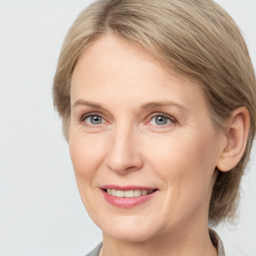 Joyful white adult female with medium  brown hair and grey eyes