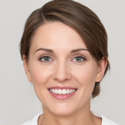 Joyful white young-adult female with medium  brown hair and grey eyes