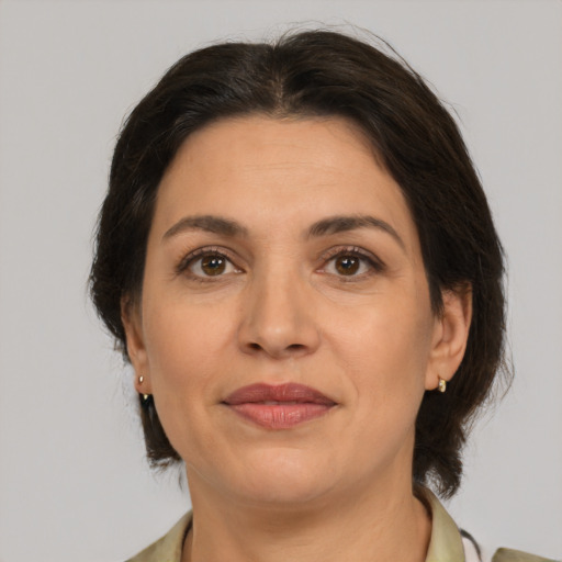Joyful latino adult female with medium  brown hair and brown eyes