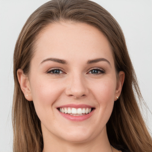 Joyful white young-adult female with long  brown hair and grey eyes