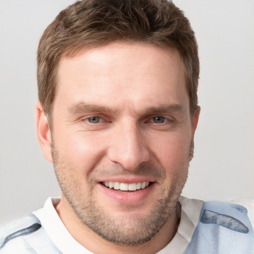 Joyful white adult male with short  brown hair and grey eyes