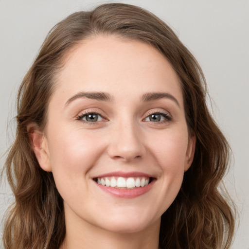 Joyful white young-adult female with long  brown hair and green eyes