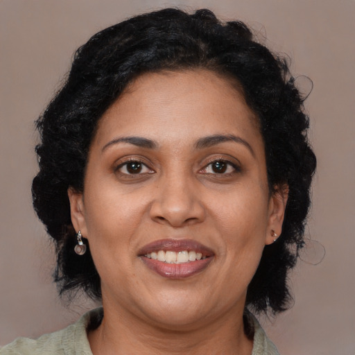 Joyful latino adult female with medium  brown hair and brown eyes