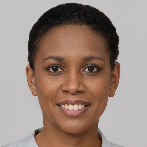 Joyful black young-adult female with short  black hair and brown eyes