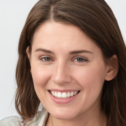 Joyful white young-adult female with long  brown hair and grey eyes