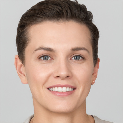 Joyful white young-adult female with short  brown hair and grey eyes