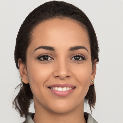 Joyful latino young-adult female with long  brown hair and brown eyes