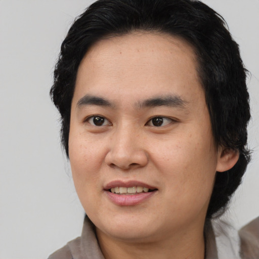 Joyful asian young-adult male with medium  brown hair and brown eyes