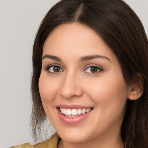 Joyful white young-adult female with long  brown hair and brown eyes