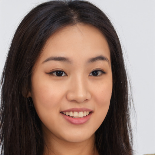 Joyful asian young-adult female with long  brown hair and brown eyes