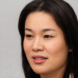 Joyful asian young-adult female with long  brown hair and brown eyes